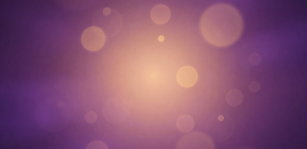 Abstract purple background with soft warm bokeh light circles.
